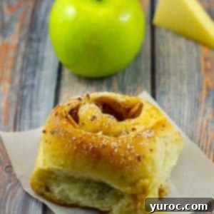bread maker cinnamon rolls on a blue surface with a green apple and slice of gruyere cheese in background