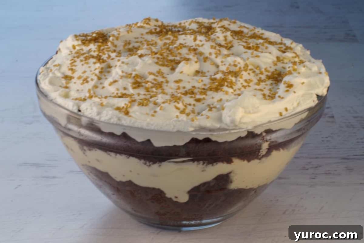 A larger, beautifully layered eggnog trifle served in a medium glass bowl, showcasing the dessert's impressive presentation and suitability for sharing at holiday gatherings.