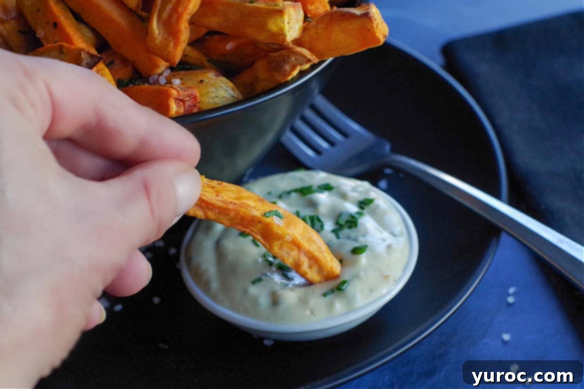 Guilt Free Greek Yogurt Spinach Artichoke Dip 7 close up of sweet potato fry being dipped into dipping sauce