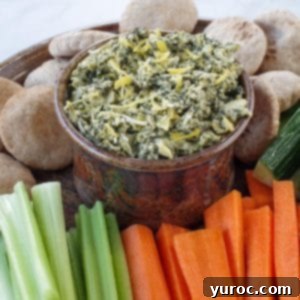 Guilt Free Greek Yogurt Spinach Artichoke Dip 9 healthy spinach artichoke dip in a ceramic bowl on a platter with vegetables and mini pita breads