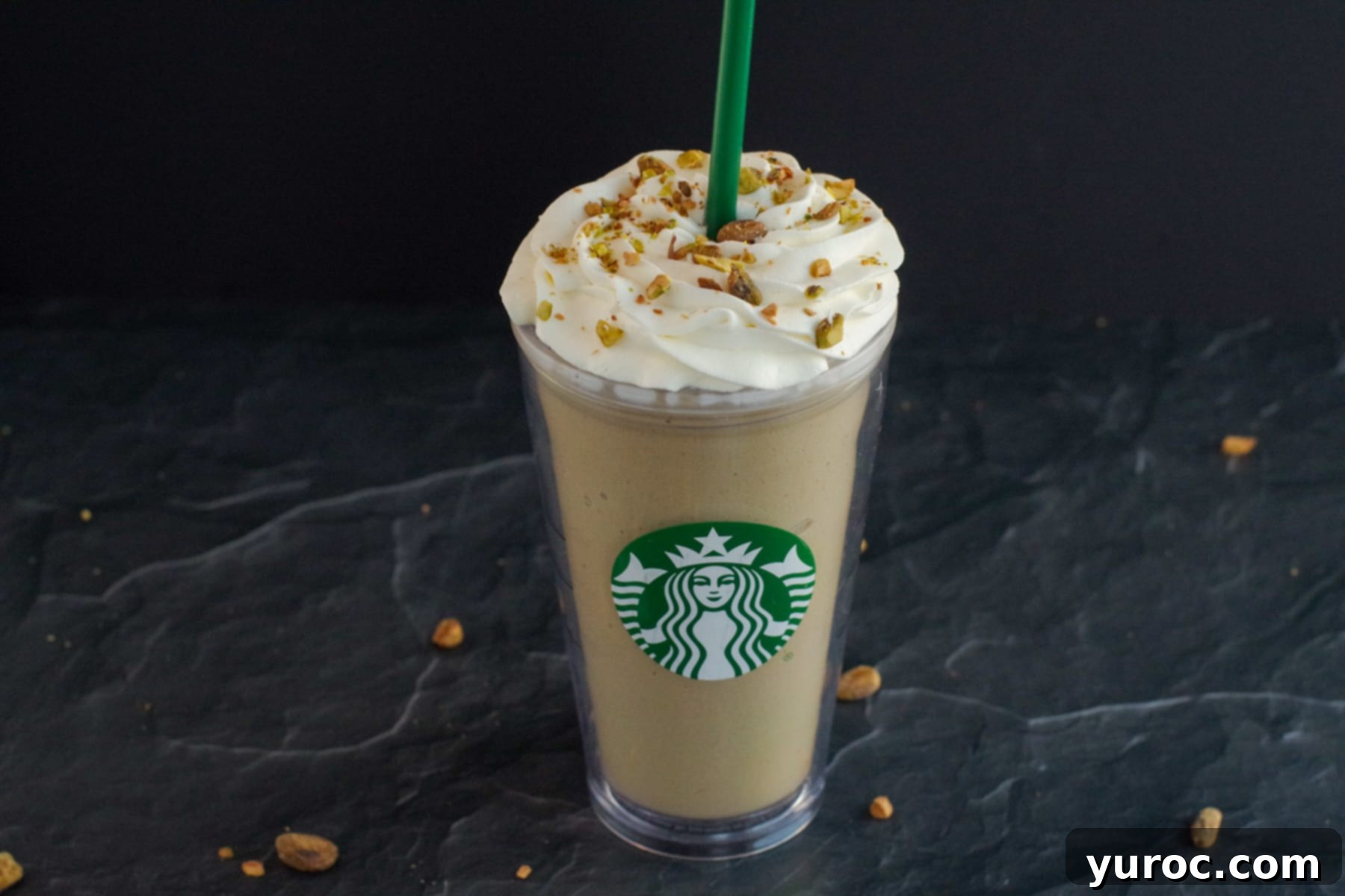 Barista-Style Pistachio Frappe 2 Pistachio Frappuccino in Starbucks cup on black surface with pistachios around
