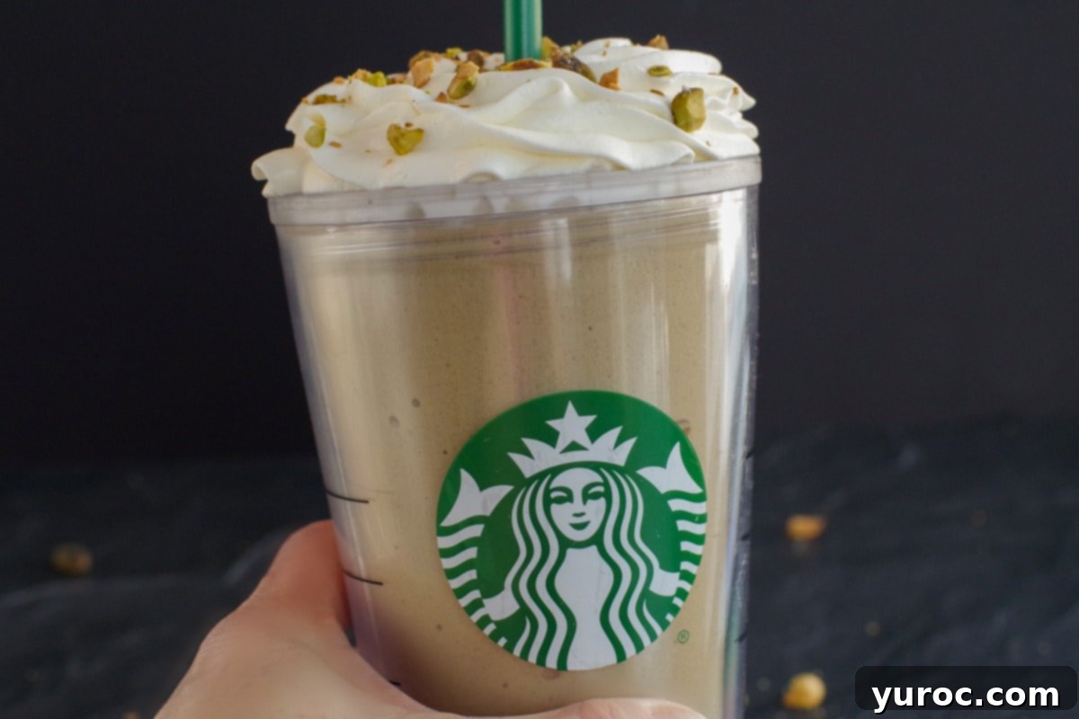 Barista-Style Pistachio Frappe 3 Starbucks Copycat Pistachio Frappuccino being held up by a hand
