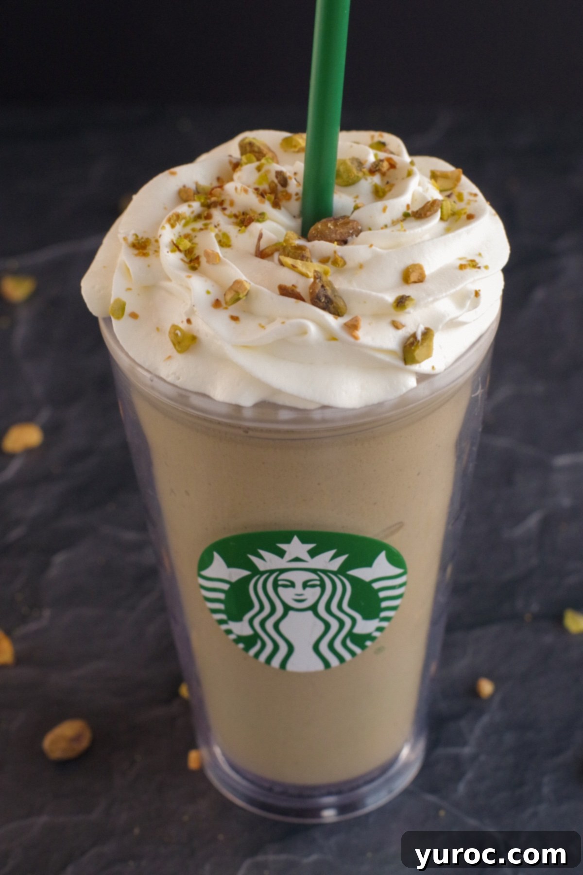 Barista-Style Pistachio Frappe 5 Pistachio Frappuccino in Starbucks cup on black surface with pistachios around