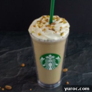 Barista-Style Pistachio Frappe 6 Pistachio Frappuccino in Starbucks cup on black surface with pistachios around