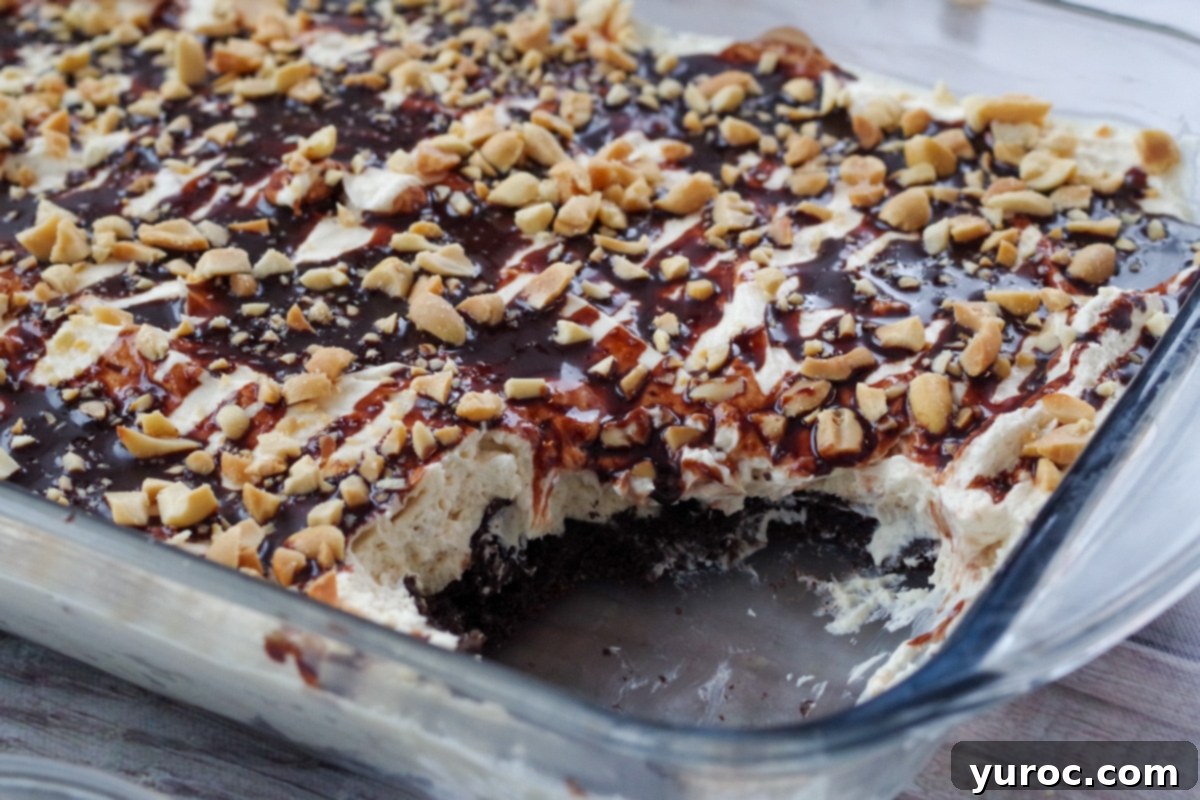 A glass pan of No-Bake Drumstick Dessert with a few slices already removed, revealing the creamy layers and crunchy crust