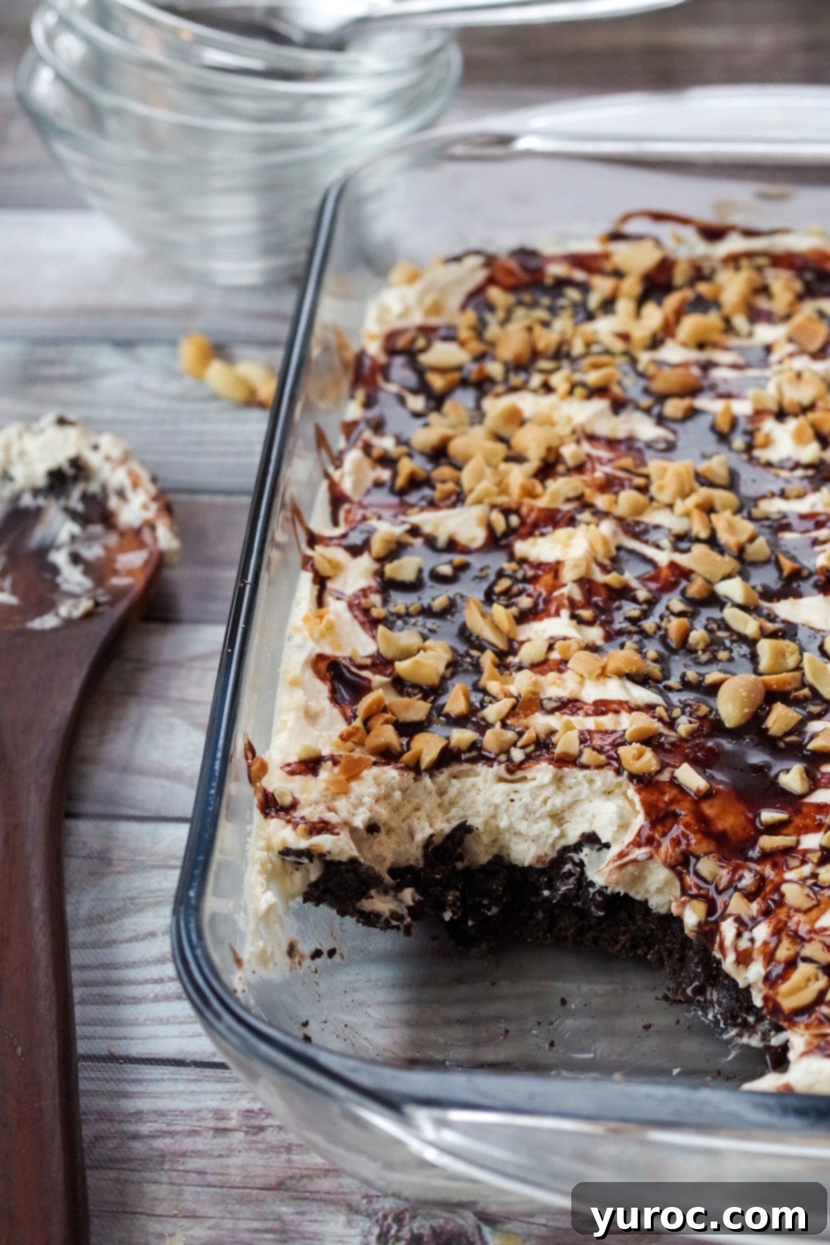 A large, perfectly cut slice of No-Bake Drumstick Dessert, showcasing the crunchy crust, creamy filling, and delightful chocolate-peanut topping