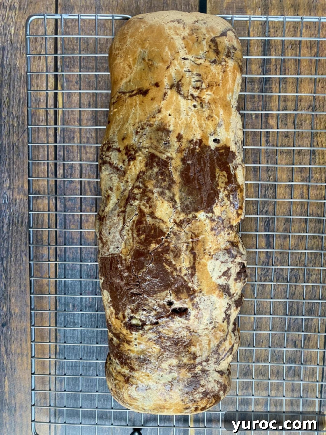 Baked marble biscotti log on a wire rack.