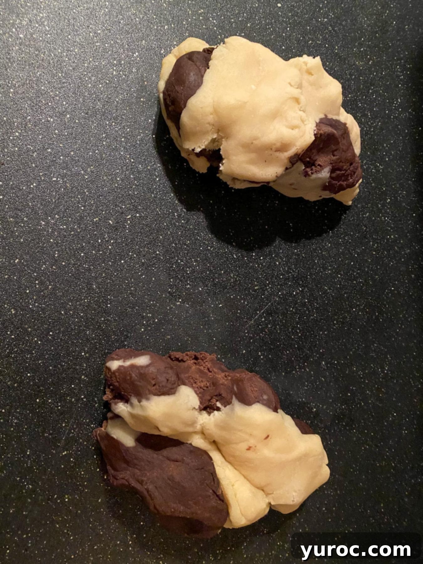 2 section of dough with both chocolate and vanilla dough starting to be mixed together/combined.