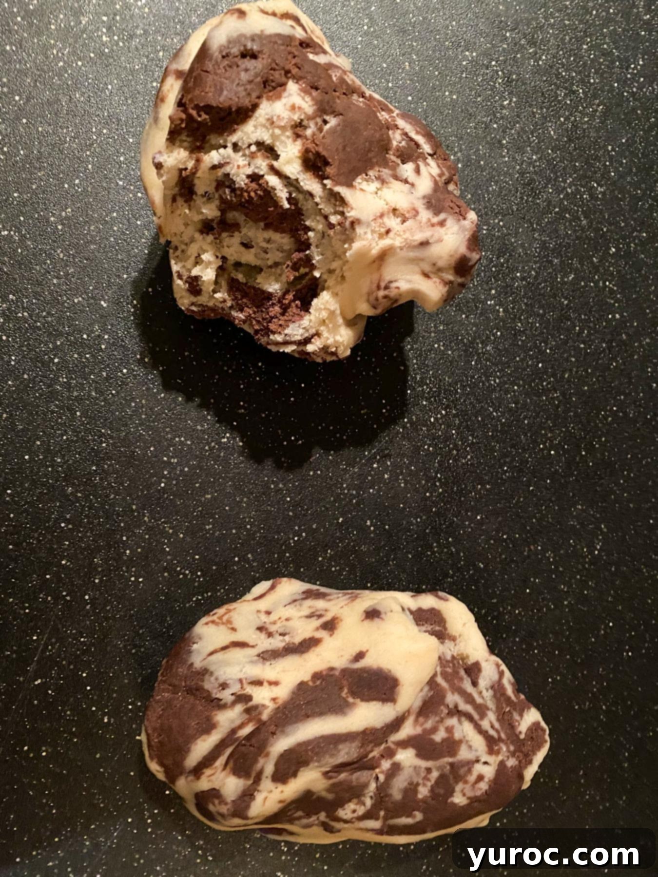 2 sections of marbled dough on a cutting board.