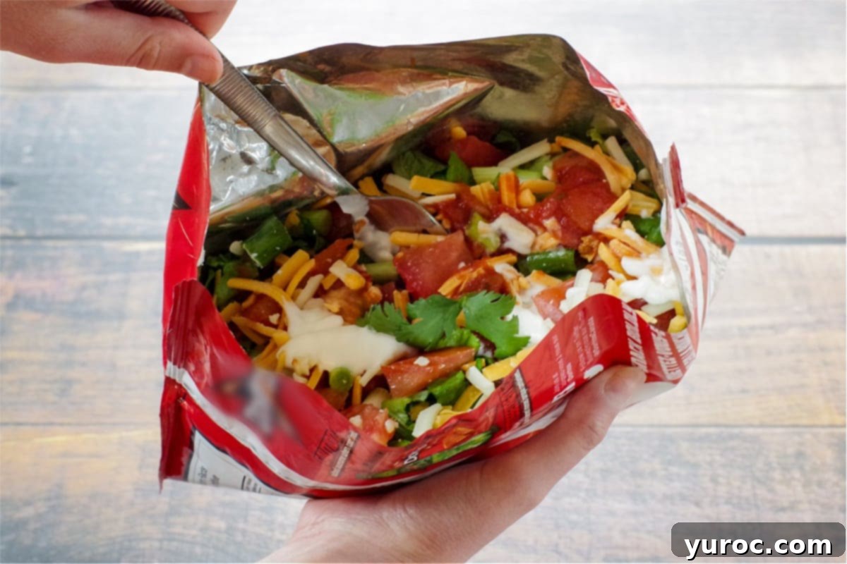 walking taco held in a hand with the other hand on a fork