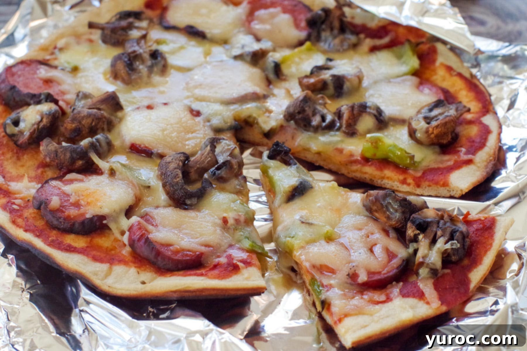 camping pizza on foil, with a slice removed