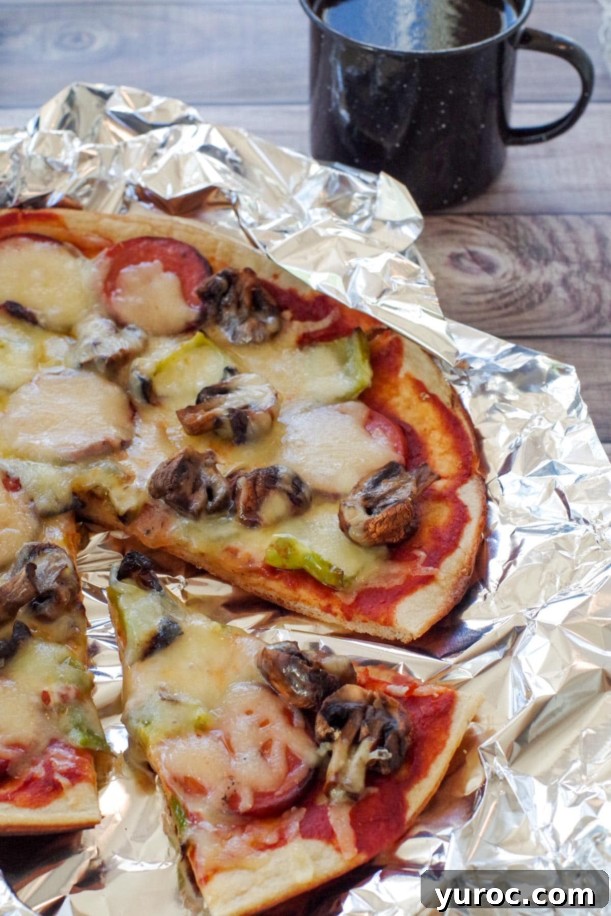 camping pizza on foil, with a slice removed