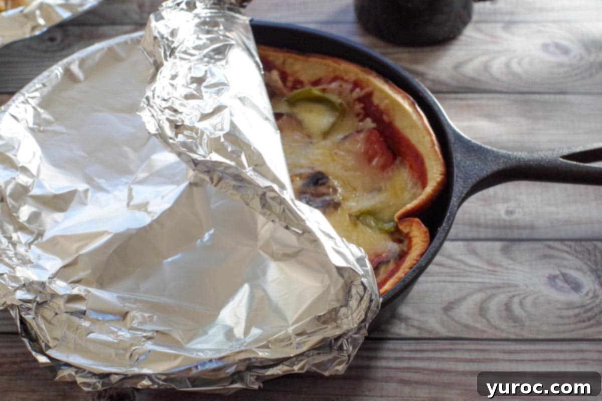cast iron pizza with foil pulled back on top
