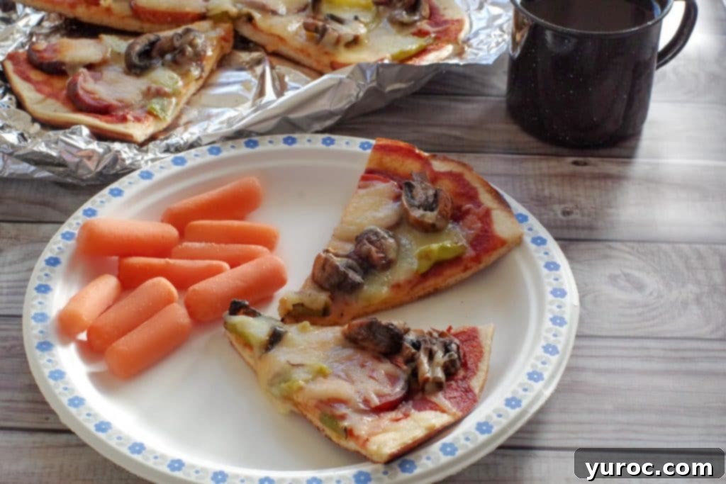 campfire pizza on paper plate with carrots on the side