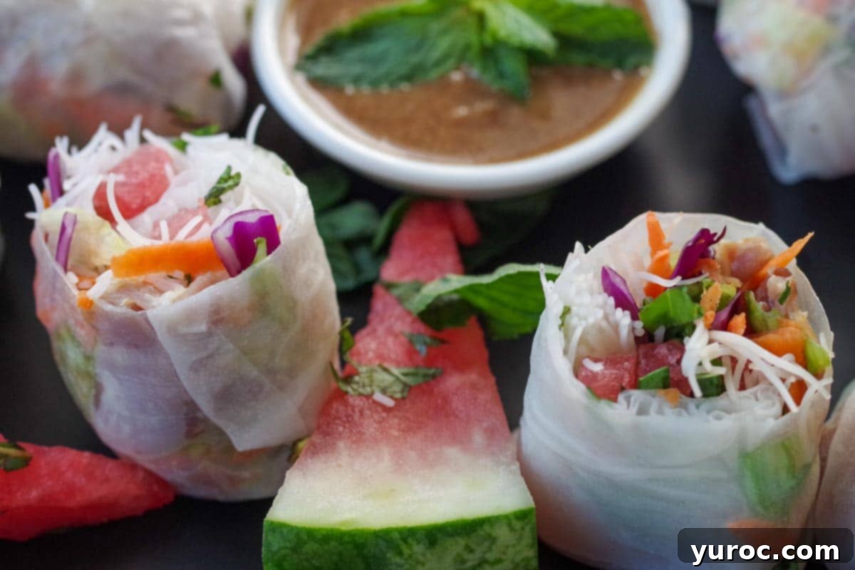 salad rolls with watermelon and prosciutto, sliced in half, with wedge of watermelon and dip in the background