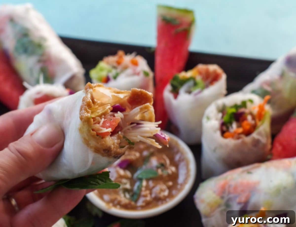 salad roll being dipped into watermelon peanut dip