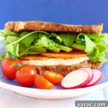 Vegan Hummus sandwich on a white plate with a blue background.