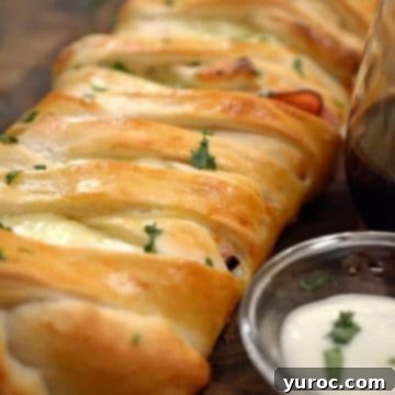 Whole crispy chicken cordon bleu stromboli with sauce on the side.