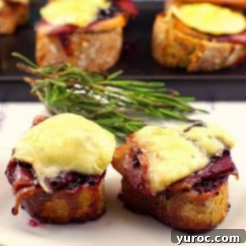 Two Turkey Brie Crostini on a white plate with more on a black platter in the background.